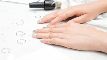 woman nail's painted midi rings lying about
