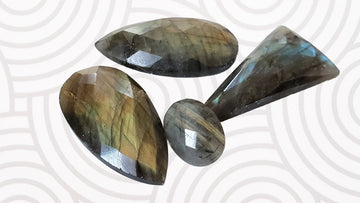 four faceted labradorite gemstones on white and gray background for a kbeau blog post about ten fun facts about labradorite