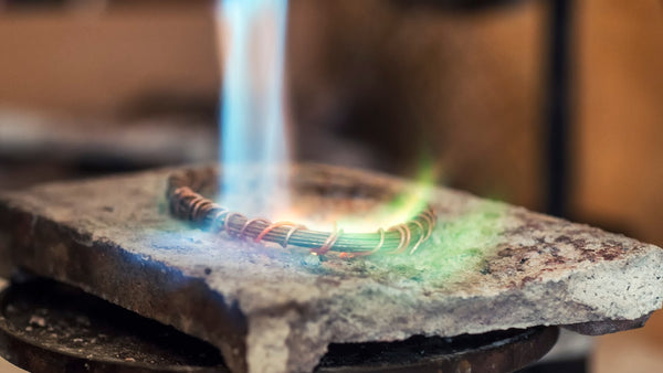 image of flame from jeweler's torch heating a piece of metal