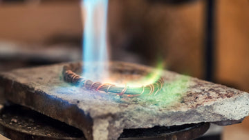 image of flame from jeweler's torch heating a piece of metal