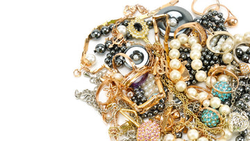 what to do with jewelry you never wear? A pile of costume jewelry on a white background