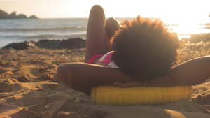 Woman lounging on beach at sunset five tips to keep your jewelry safe this summer