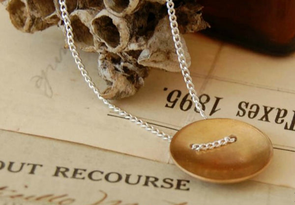 A bronze domed disc on a sterling silver chain